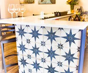The bright blue tiles provide a beautiful pop of color in the bar